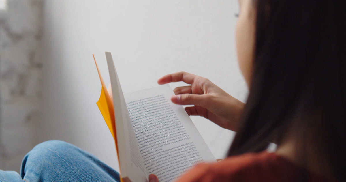 A woman turning the pages of a book